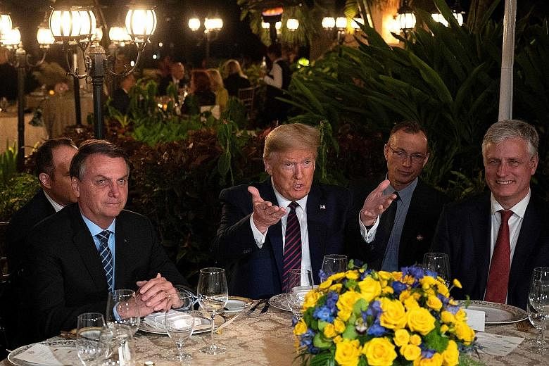 US President Donald Trump with Brazilian President Jair Bolsonaro (far left) at a dinner at Mar-a-Lago in Palm Beach, Florida, last Saturday. When asked if he would continue to hold off placing new tariffs on Brazilian steel and aluminium, Mr Trump s