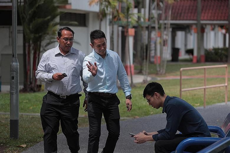 Senior Staff Sergeant Mohamad Shapie Saleh (left) and Sergeant Loh Seng Hong showing how they would conduct interviews in the field. Officers use their usual investigative methods to hunt down close contacts - analysing surveillance footage and speak