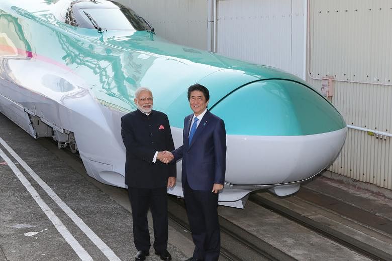 Indian Prime Minister Narendra Modi and his Japanese counterpart Shinzo Abe with a shinkansen train in Kobe, Japan, in this 2016 picture. India's high-speed rail project is developed with the Japanese.