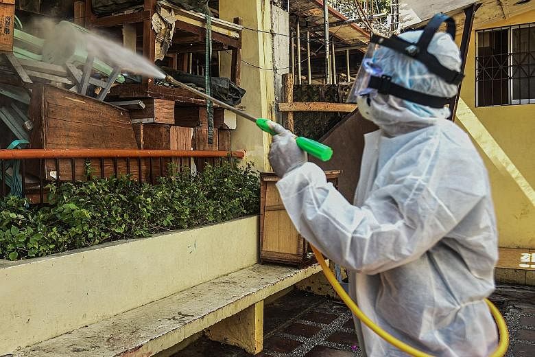 A worker disinfecting a high school in Manila yesterday. Declaring a health emergency releases funds to help local governments prepare for a massive community spread in the Philippines.