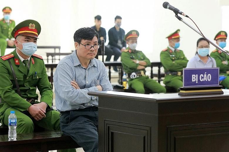 Truong Duy Nhat (centre) on trial in Hanoi on Monday. The journalist is known for his criticism of the ruling Communist Party. PHOTO: AGENCE FRANCE-PRESSE