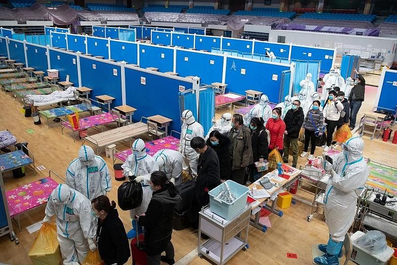 Staff and patients leaving, after all patients were discharged from Wuhan's Wuchang Fangcang hospital, which was temporarily set up to treat coronavirus patients. PHOTO: EPA-EFE