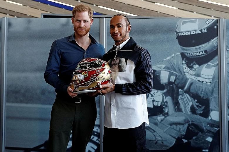 Britain's Prince Harry and Mercedes' F1 world champion driver Lewis Hamilton during the official opening of Silverstone Experience, the British motor racing museum, last Friday. PHOTO: AGENCE FRANCE-PRESSE
