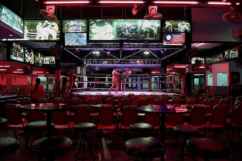 Muay thai fighters performing inside an empty bar in Pattaya on Wednesday, as tourist arrivals fell. PHOTO: REUTERS