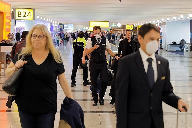 Travellers wearing masks at John F. Kennedy International Airport in New York. The Department of Homeland Security said the travel restrictions would cover foreign nationals who had been in Europe in the past 14 days. United States President Donald T