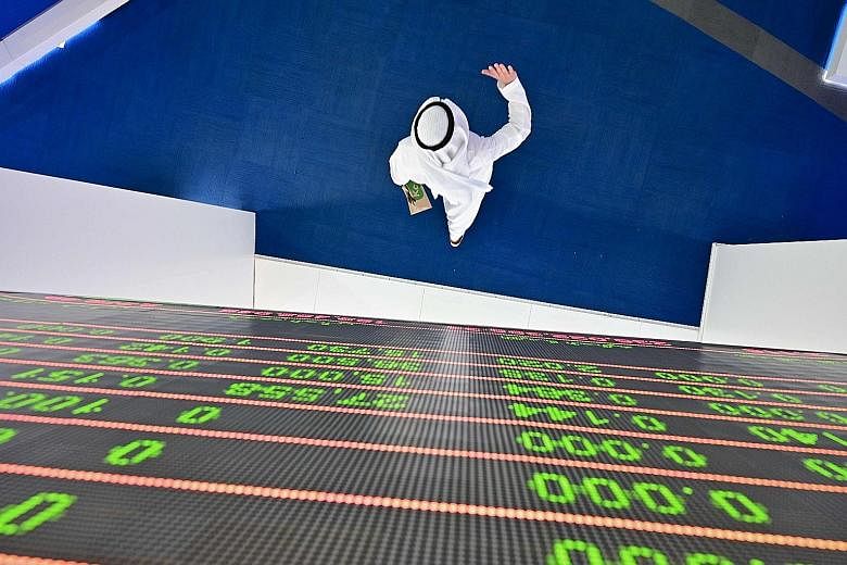 A trader walking beneath a stock display board at the Dubai Stock Exchange in the United Arab Emirates. The Saudi-Russian oil arrangement collapsed last Friday, when Saudi officials were stunned to discover that Russia not only refused to consider pr