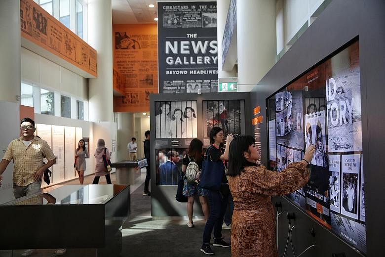 Invited guests exploring the National Library's new permanent exhibition, called The News Gallery: Beyond Headlines, yesterday. It includes interactive screens showing how different newspapers covered events in the nation's past, such as the Maria He