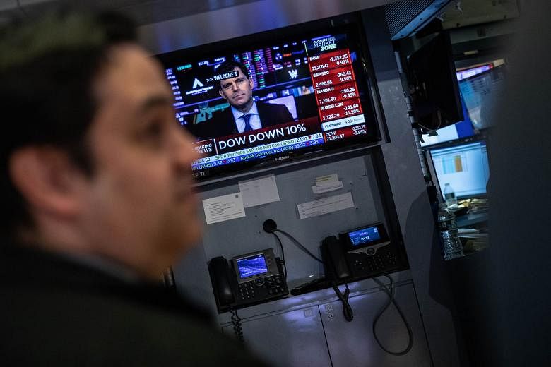 A trader at the New York Stock Exchange on Thursday. The falls overnight - the biggest on Wall Street since the October 1987 crash - sent the Straits Times Index plunging by as much as 6.3 per cent within the first hour of trading before it pared los