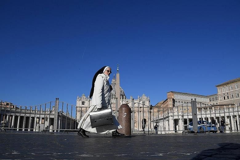 ROME, ITALY: A nun walking past an empty St Peter's Square, on the third day of an unprecedented lockdown across Italy on Thursday.