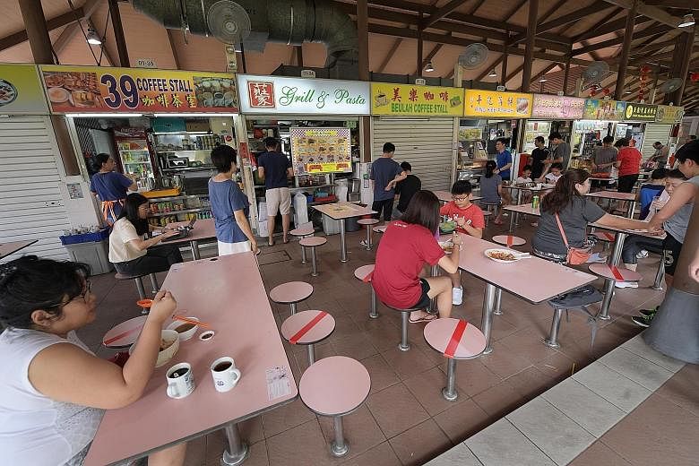 At Sembawang Hills Food Centre yesterday, alternate seats were marked with red tape to indicate that these should not be used. People at a movie screening at Our Tampines Hub yesterday. Owners and tenants of venues that are publicly accessible have b
