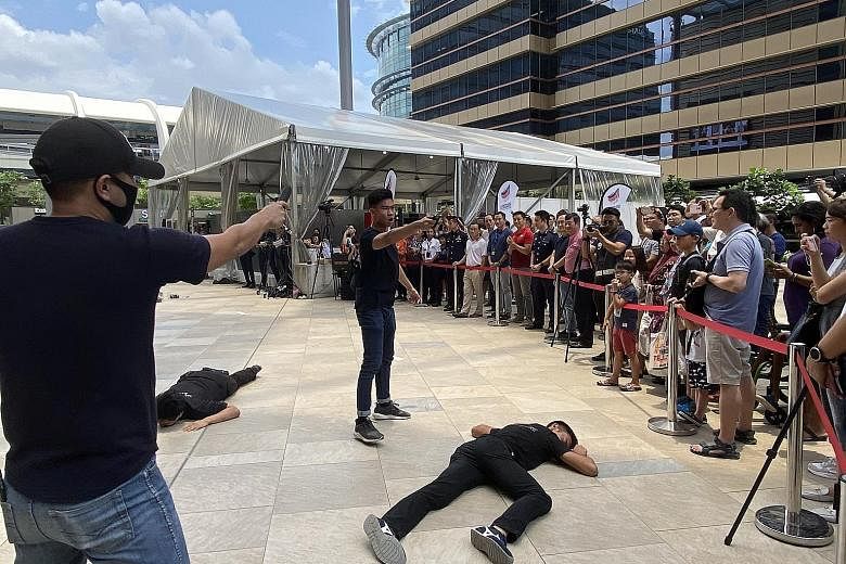Speaker of Parliament Tan Chuan-Jin (in red), along with other MPs in the area, viewing an exercise demonstration at an SGSecure roadshow outside the Paya Lebar Quarter mall yesterday.