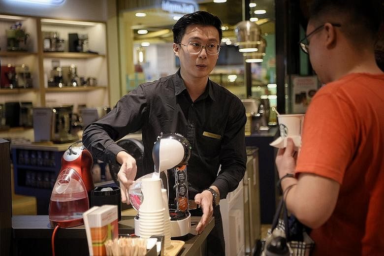 Mr Dylan Teo, a coffee-making machine promoter at Tangs department store, giving out coffee samples.