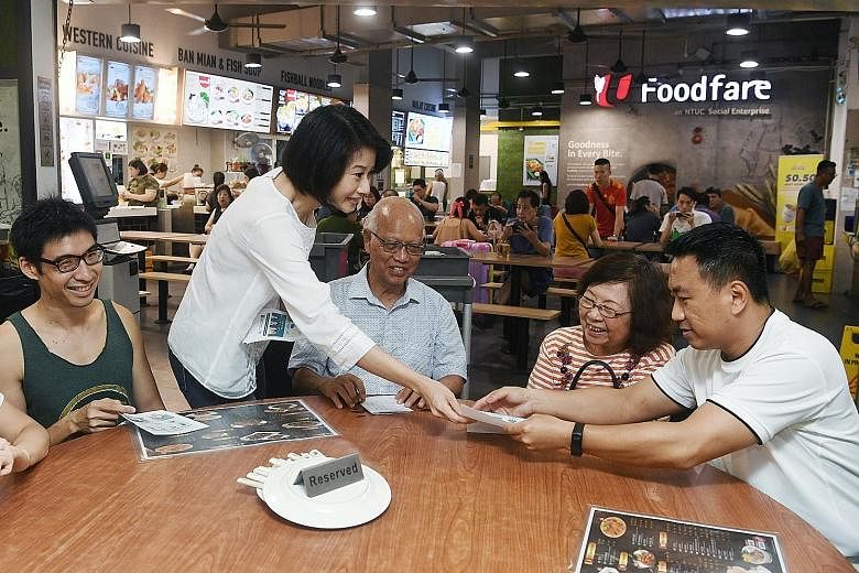 MP Sun Xueling distributing fliers on Covid-19 to residents at a coffee shop in Punggol yesterday. The first-term MP, whose Punggol West ward has been carved out as a single seat, said she has been walking the ground and engaging residents consistent