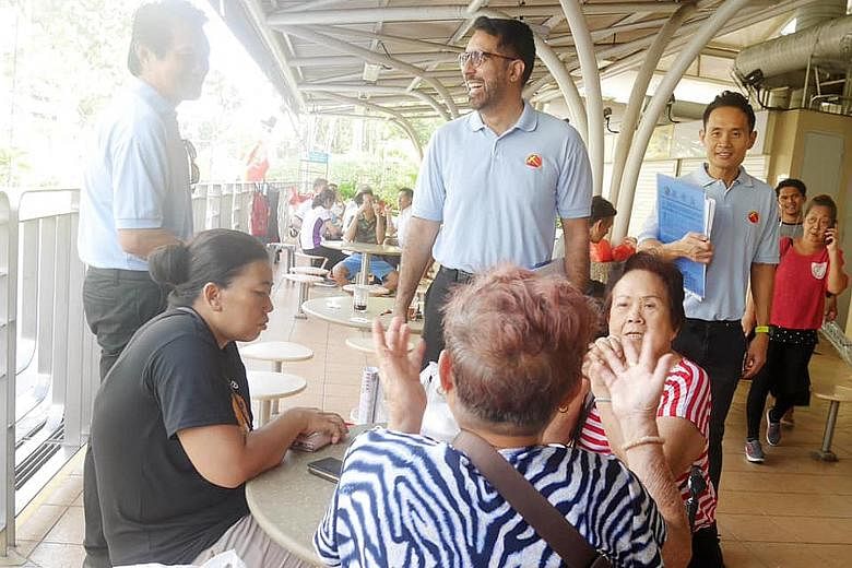 Workers' Party chief Pritam Singh (centre) and member Kenneth Foo (right) at the Eunos division of the WP-held Aljunied GRC earlier this month.