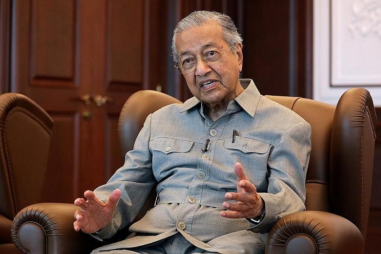 Former premier Mahathir Mohamad being interviewed by Reuters last week. His son Mukhriz Mahathir (right), seen here in a 2016 file photo, is deputy president of Parti Pribumi Bersatu Malaysia and is challenging Prime Minister Muhyiddin Yassin for the