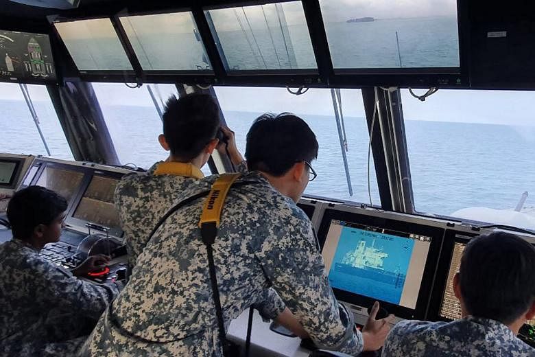 Navy personnel on board RSS Independence monitoring the Sam Jaguar, which was hit by pirates yesterday. PHOTO: MINDEF