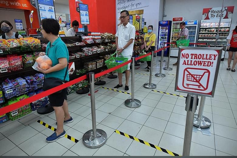 Shoppers at FairPrice in Nex queueing a metre apart by following floor markers. Safe distancing will also be the norm at other public areas such as entertainment venues, restaurants, hawker centres and cinemas. ST PHOTO: NG SOR LUAN