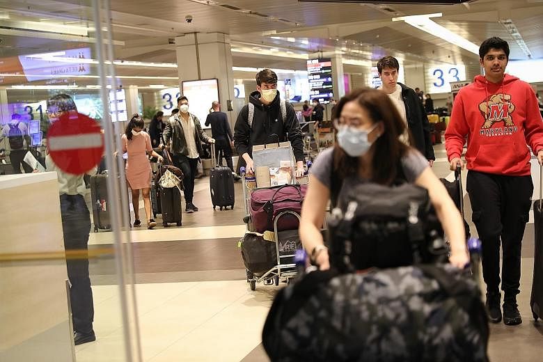 Passengers from a New York flight arriving at Changi Airport Terminal 2 on Thursday. Among the Singaporeans returning from overseas are students whose parents were worried about their safety and wanted them to come back as soon as possible. For some,