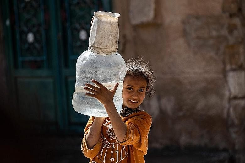 A girl carrying a container filled with water amid shortage in the Kurdish city of Al-Hasakah, in north-eastern Syria, earlier this month.