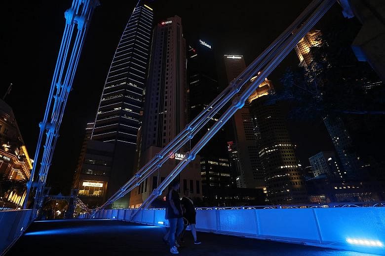 Cavenagh Bridge in the Central Business District lit up in blue yesterday under national water agency PUB's City Turns Blue initiative.