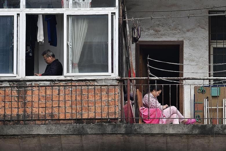 People at a residential compound in Wuhan, Hubei province, on March 10. As new Wuhan party secretary Wang Zhonglin's mandate was to contain the epidemic, he is still perceived by the party to have done his job despite the gaffes, insiders said. He ma