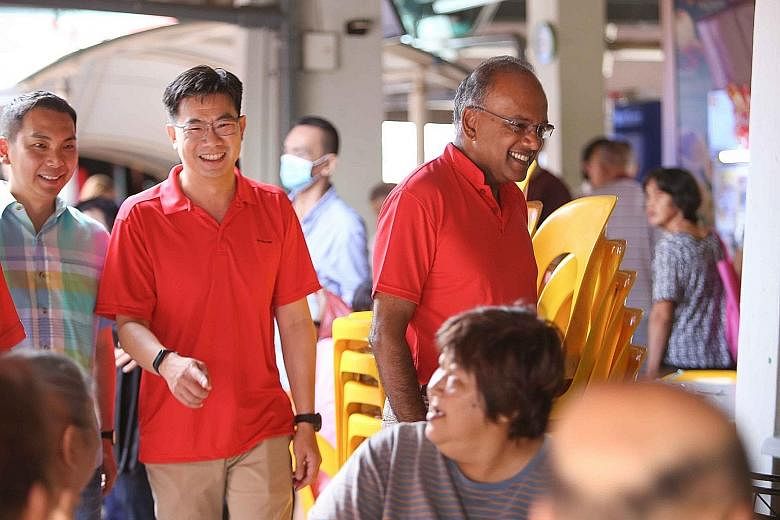 Above: Changi Airport Group vice-president Poh Li San, who has recently appeared in Sembawang GRC, distributing care packs to cleaners last Saturday. ST PHOTO: NG SOR LUAN Left: Home Affairs and Law Minister K. Shanmugam with Mr Derrick Goh, managing