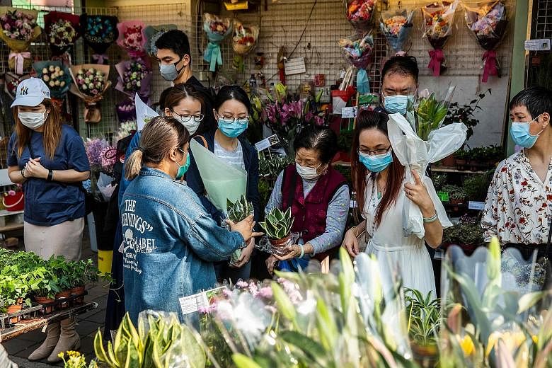 People wearing face masks on Sunday as they shopped for plants and flowers in Hong Kong, which saw its confirmed coronavirus cases go up by 39 to 356 yesterday.