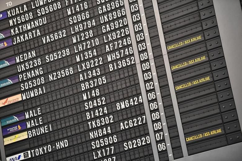 The flight information board at Changi Airport's Terminal 2 showing flight cancellations yesterday. SIA said it is especially vulnerable to international restrictions in air travel because it does not have a domestic segment. ST PHOTO: ARIFFIN JAMAR