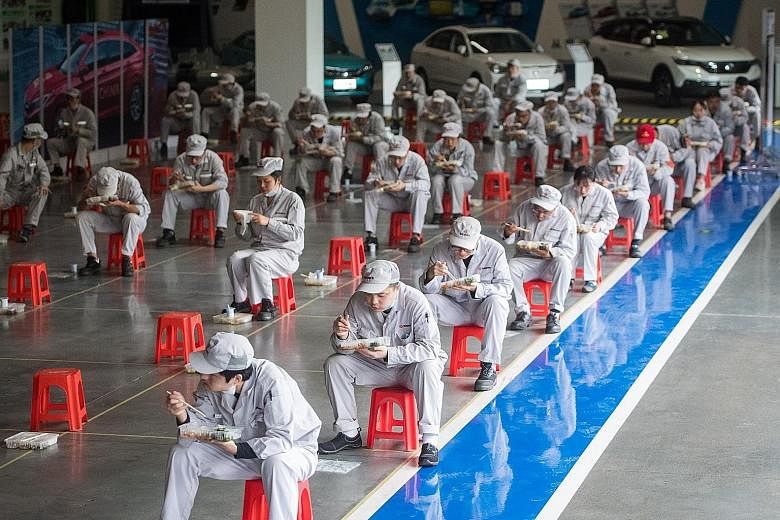 Workers at Dongfeng Passenger Car Company in Wuhan, Hubei province, maintaining a distance from one another during lunch yesterday. The easing of restrictions there comes as health officials claim the Covid-19 situation has been brought under control