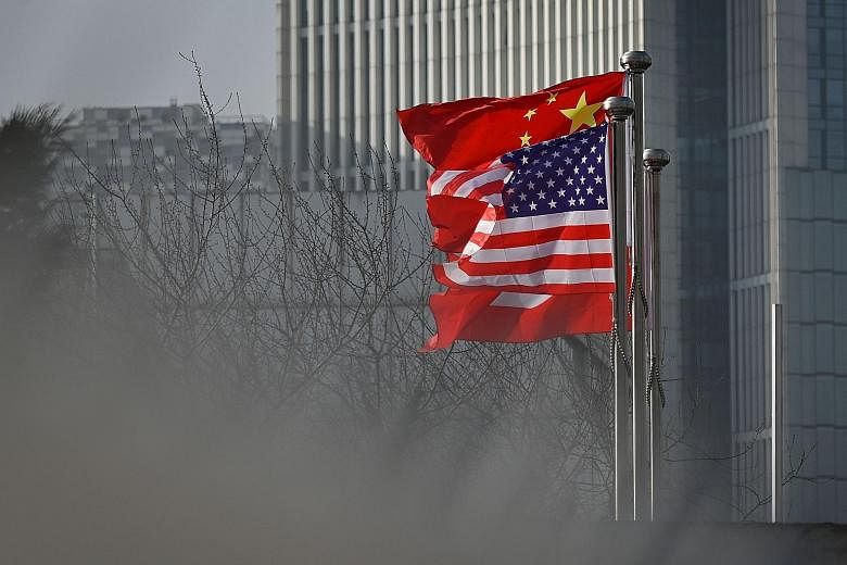 Chinese and US national flags outside an office building in Beijing. Last week, China announced that all American journalists at three US papers based in the country whose credentials were set to expire this year had to hand in their press cards with