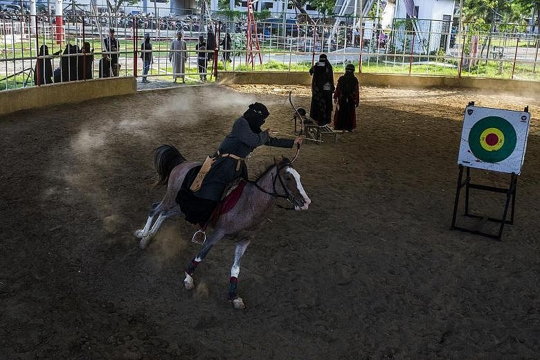 A veiled woman on horseback honing her archery skills at the Al Fatah Islamic Boarding School in Temboro, a village in East Java, Indonesia. PHOTO: NYTIMES