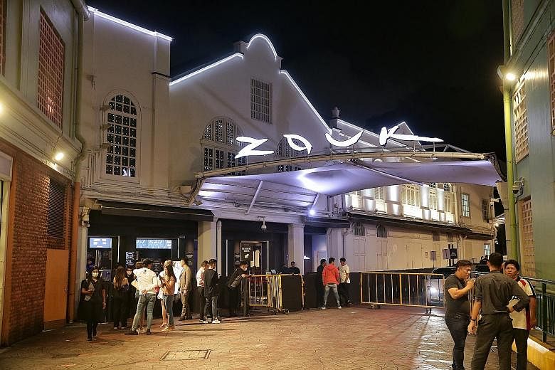 Club-goers did not have to wait long to enter popular nightclubs like Zouk (above), while at Le Noir (left), a bar at Clarke Quay, only a handful of patrons were spotted. ST PHOTOS: KEVIN LIM