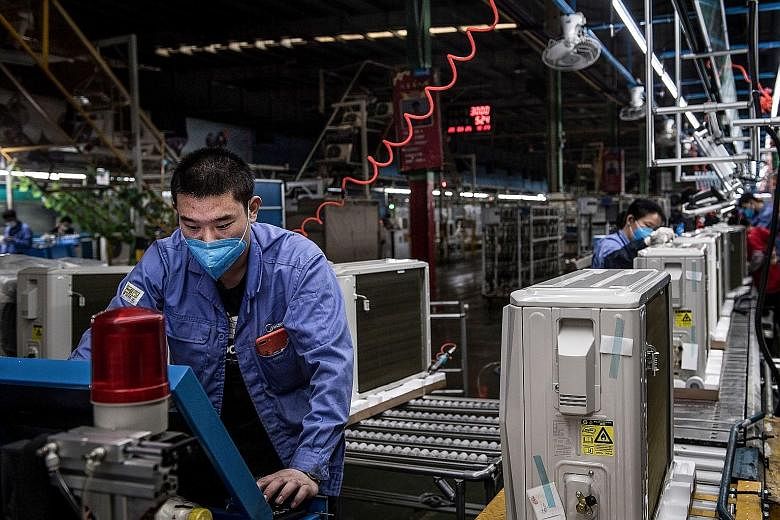 A worker at an air-conditioner production line at a Midea factory in Wuhan on Wednesday. Before the coronavirus outbreak, China's manufacturing sector was already suffering from the trade war with the US.
