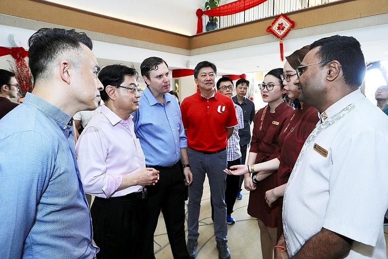 Left: Healthcare workers in the Singapore General Hospital isolation ward assisting in the transfer of a suspected Covid-19 patient to an isolation room. Singapore yesterday reported 52 new coronavirus cases. ST PHOTO: NEO XIAOBIN Above: Deputy Prime