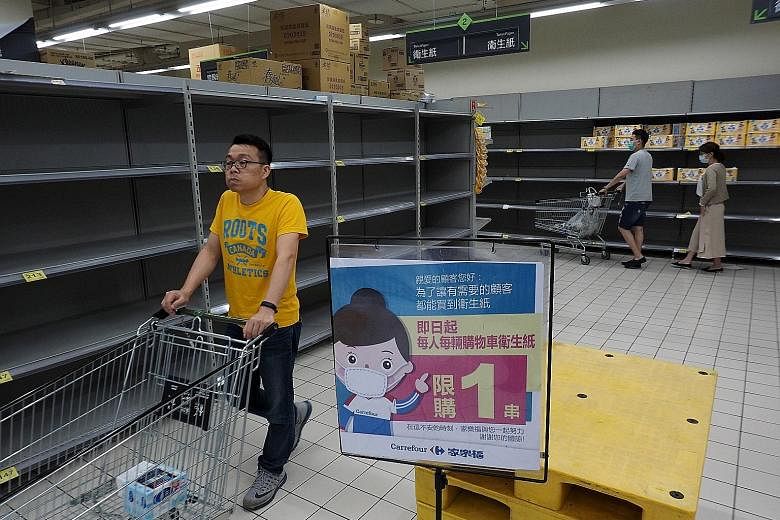 Empty shelves usually stacked with toilet paper at a Carrefour supermarket in New Taipei City last week. Panic buying of household staples such as toilet paper has occurred in nearly every country hit by the coronavirus. Sacks of rice at a National F
