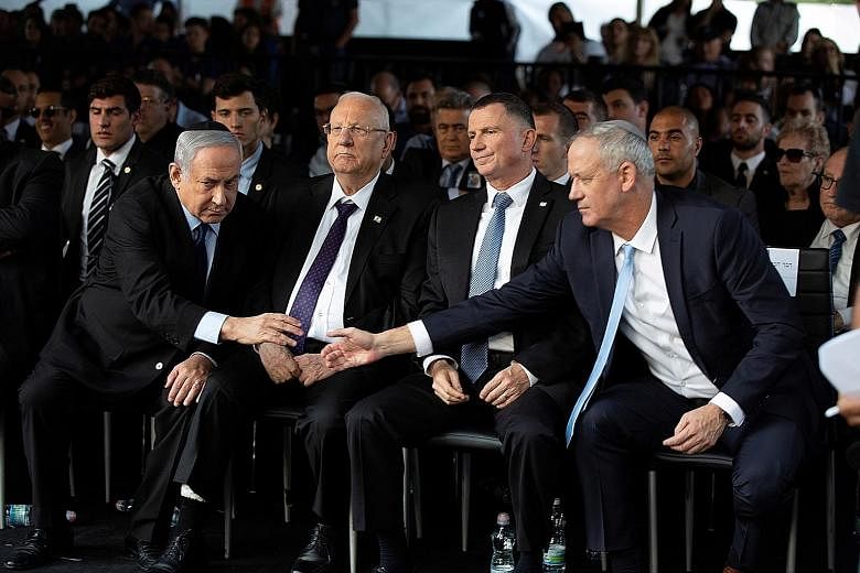 Israeli Prime Minister Benjamin Netanyahu and Mr Benny Gantz shaking hands in this 2019 file photo. Many of Mr Gantz's allies are furious over the possibility he could form an alliance with a leader under criminal indictment. PHOTO: REUTERS