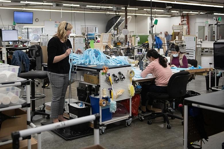 Workers making protective masks at Kaas Tailored's manufacturing facility in Mukilteo, Washington in the US on Thursday. America was slow to ramp up testing for the broader population, and personal protective equipment such as masks and medical equip