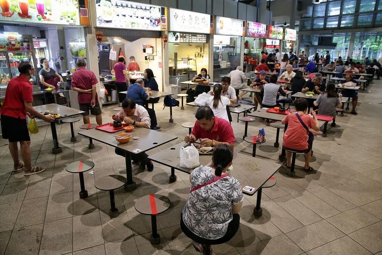 Members of the public practising social distancing while dining at the Bedok Interchange Hawker Centre.