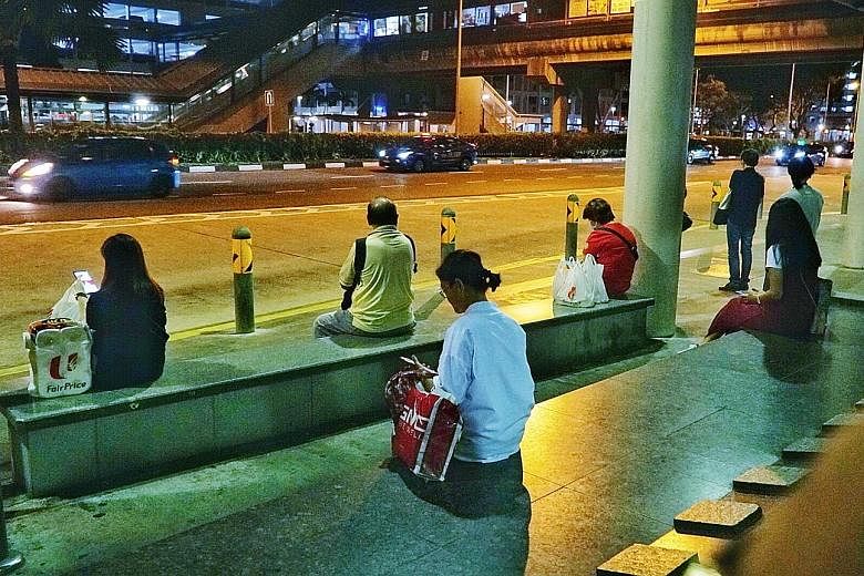 Commuters observing safe distancing at a bus stop near Admiralty MRT station. As Singapore battles a second surge of Covid-19 cases, many of whom are returning residents or long-term pass holders, bars and other entertainment outlets have been ordere