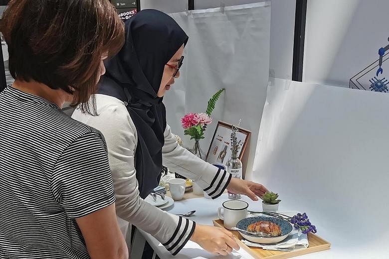 Ms Athirah Azlan (above right) showing how to style and photograph products in a workshop conducted by Lookeesan Creatives.