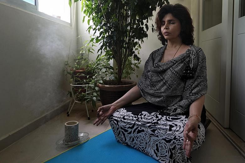 The writer practising pranayama, a breath-control technique, at her balcony, which she has repurposed into her meditation spot.
