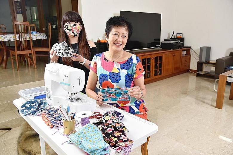 Writer Hedy Khoo wearing a duckbill-shaped face mask while her mother, Mrs Sheila Khoo, who sews the masks at home, is holding one with a pleated design that resembles surgical masks.