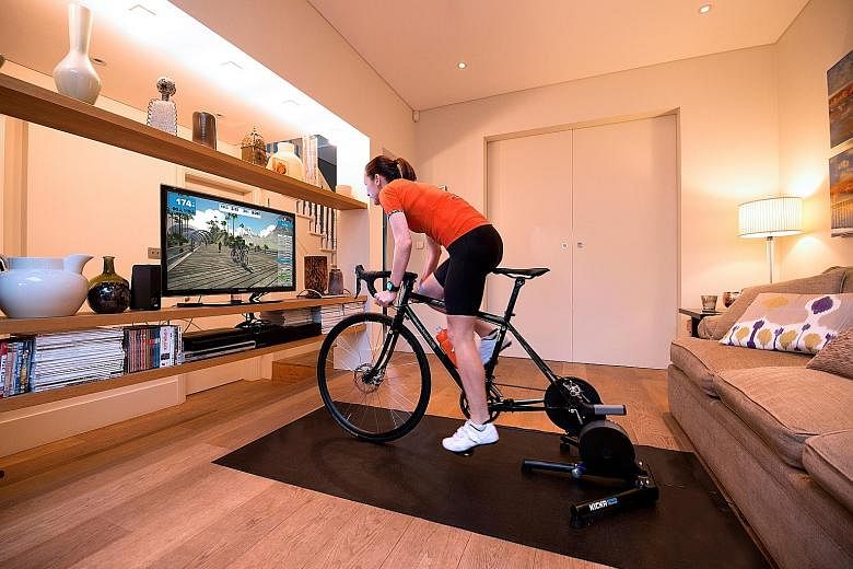 Main photo: A home indoor trainer with Zwift app set-up. Top: 2018 Tour de France champion Geraint Thomas and Zwift CEO Eric Min in a virtual ride. PHOTOS: ZWIFT Above: A Peloton exercise bike. PHOTO: REUTERS