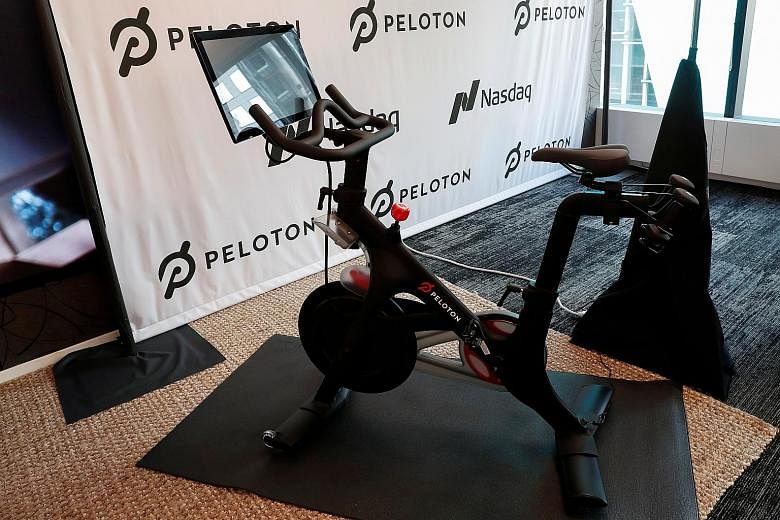 Main photo: A home indoor trainer with Zwift app set-up. Top: 2018 Tour de France champion Geraint Thomas and Zwift CEO Eric Min in a virtual ride. PHOTOS: ZWIFT Above: A Peloton exercise bike. PHOTO: REUTERS