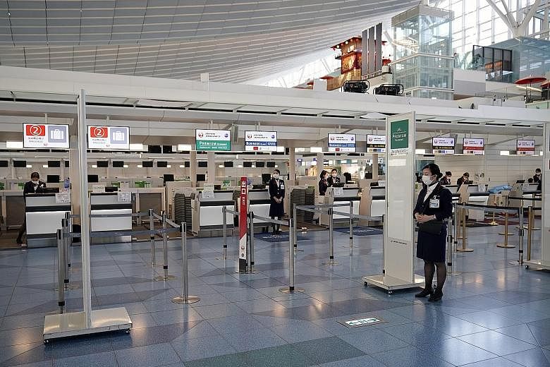 Japan Airlines ground staff wearing face masks at Haneda Airport earlier this month. The coronavirus crisis led to a 58.3 per cent plunge in tourist arrivals in Japan last month, and this is set to worsen with the worldwide travel restrictions that a