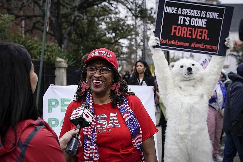 A supporter of President Donald Trump being interviewed while a climate change activist dressed as a polar bear demonstrated ahead of a Democratic presidential debate in South Carolina last month. President Trump has made rolling back environmental r