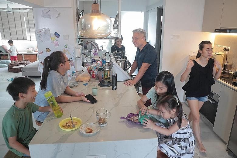 Ms Elizabeth Chang (at right), 42, and her husband Kelvin Koh, 45, at their home yesterday with their children - (from left) Micah (in background), six; Noah, nine; Kyra, 14; Nessya, 11; and Mikaela, four - and their maid Maliana (centre, background)