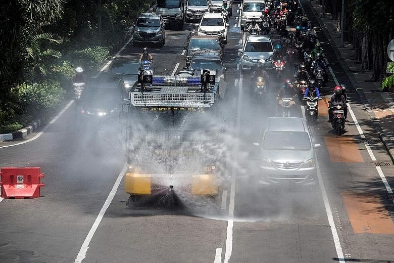 A police riot control vehicle spraying disinfectant in Surabaya in East Java province yesterday. Indonesia's government fears that Covid-19 is spreading as thousands of people from Jakarta, the epicentre of the country's outbreak, return to their hom