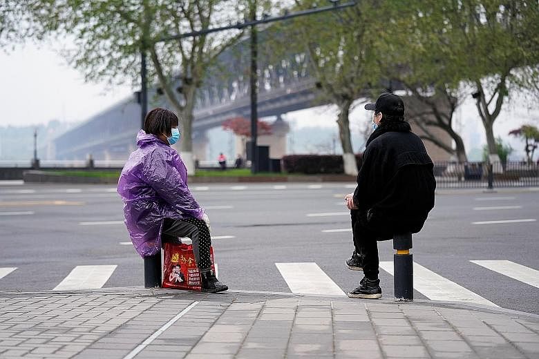 Masked people practising social distancing in Wuhan, Hubei province, yesterday. A study shows that up to 86 per cent of infections in China had gone undetected in the weeks leading up to the lockdown in Wuhan, the epicentre of the outbreak, on Jan 23