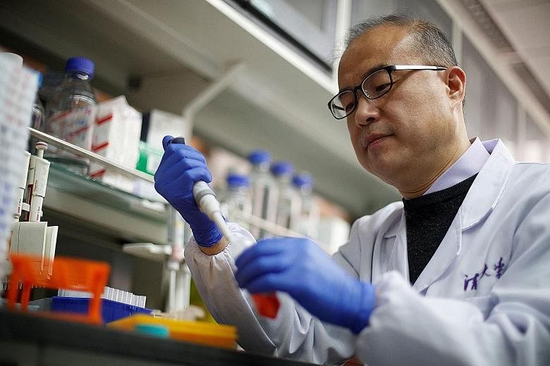 Dr Zhang Linqi demonstrating work in his laboratory at Tsinghua University in Beijing, where his team is researching antibodies that could block the ability of the coronavirus to enter cells, which eventually could be helpful in treating or preventin